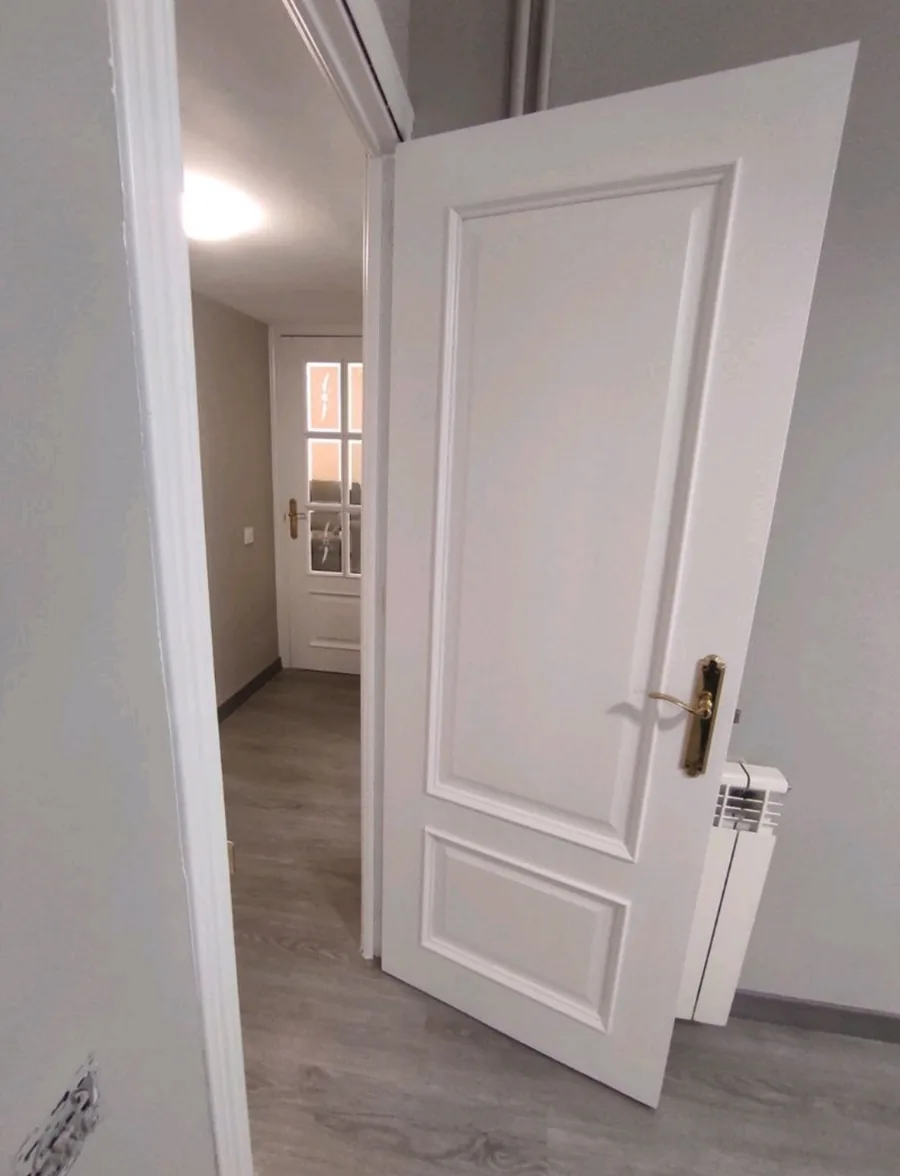 Puertas de corredor lacadas en blanco sobre pared clara