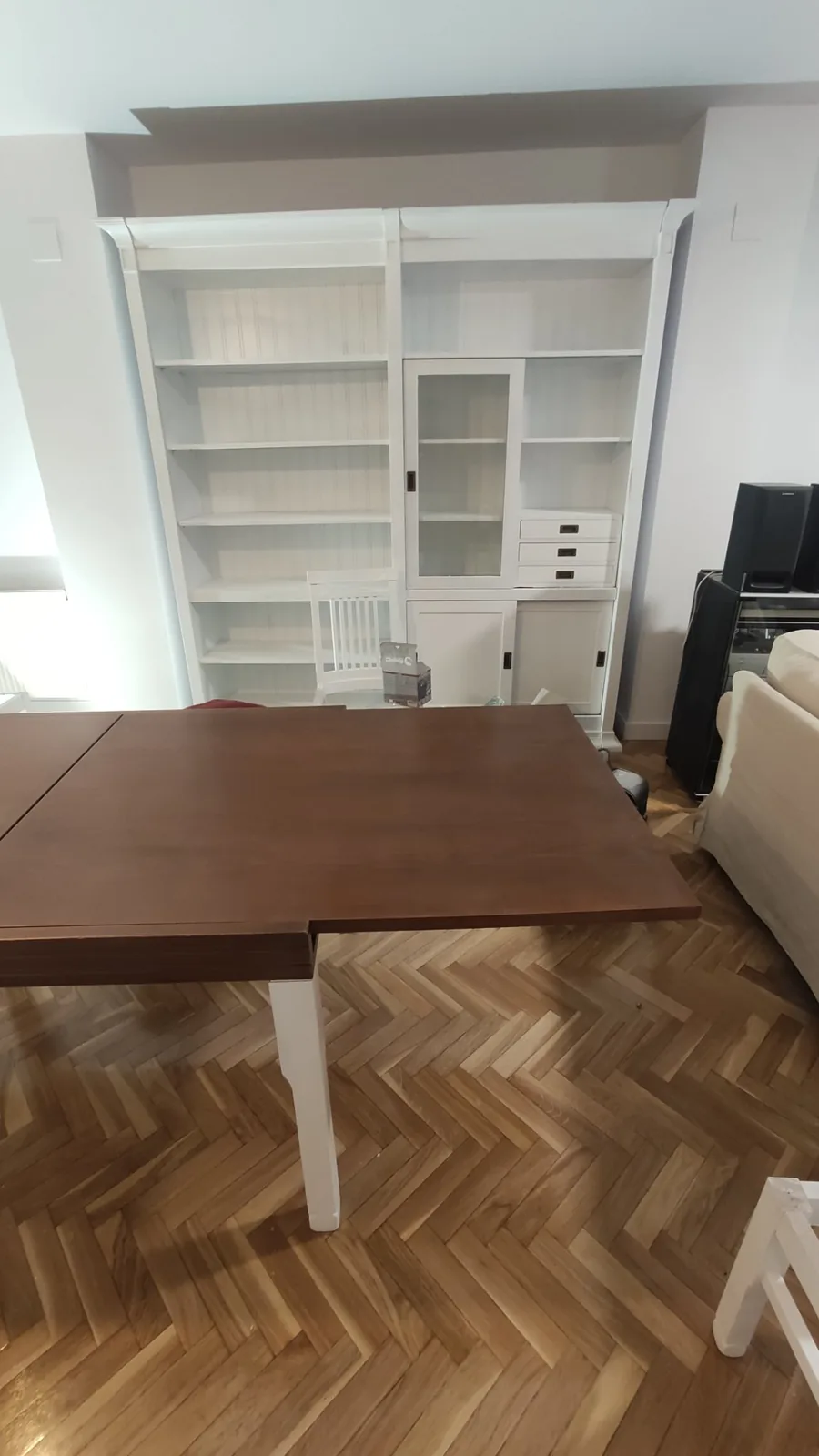 Salón con pared blanca y librería lacada en blanco